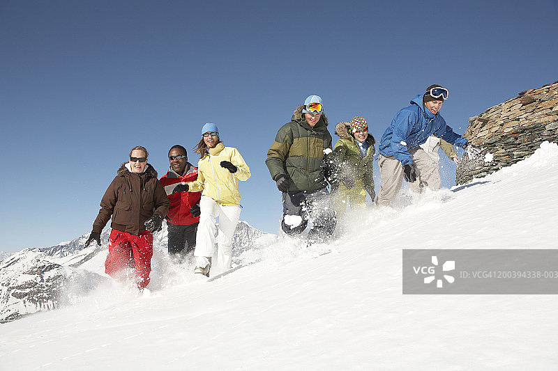 一群朋友在雪坡上跑下来图片素材
