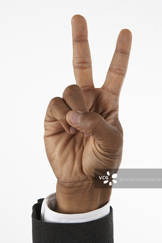 伸出两根手指的商人（聚焦手部）图片素材