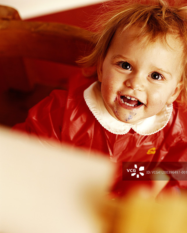 向上看，微笑的女婴（18-24个月）（焦点在女孩身上）图片素材