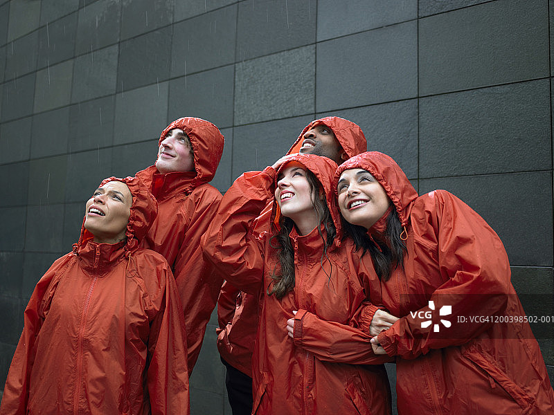 一群穿着防风外套的人在雨中抬头图片素材