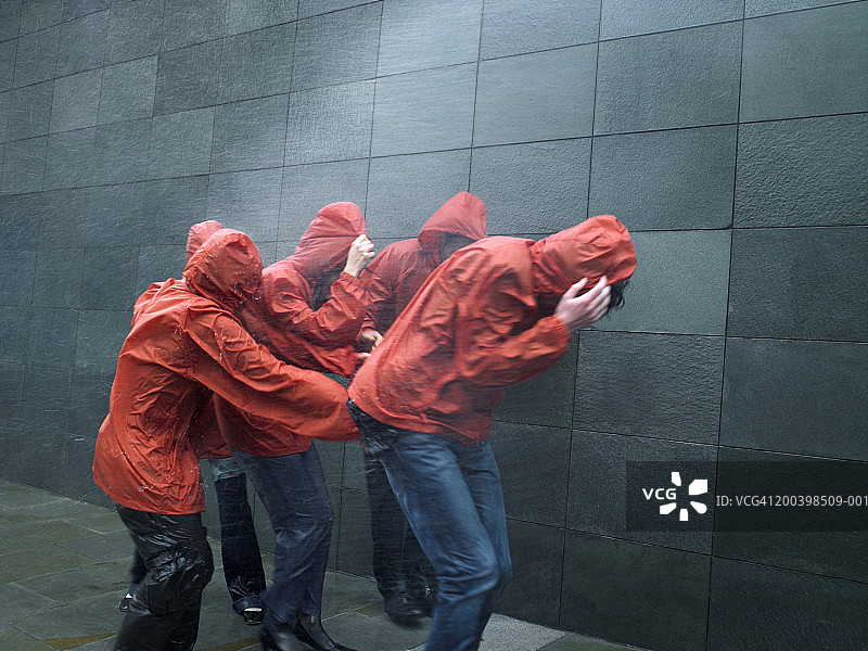 一群穿着滑雪衫的人在暴雨中艰难行走图片素材