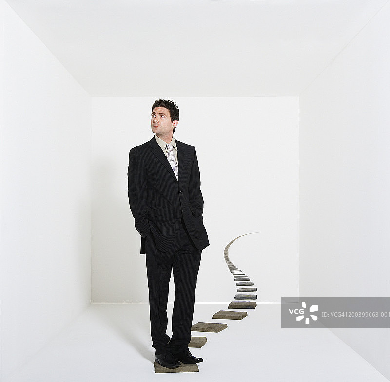 在白色房间里踩着垫脚石的商人图片素材