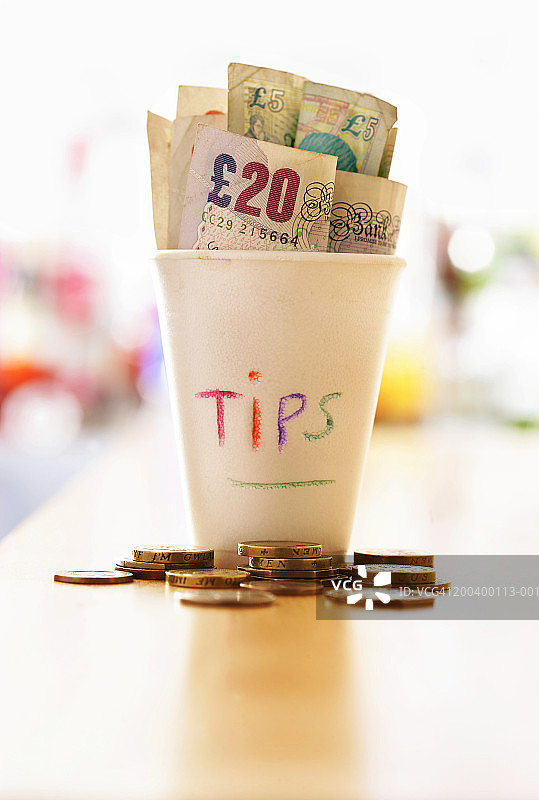 桌子上的小费罐里的钱图片素材