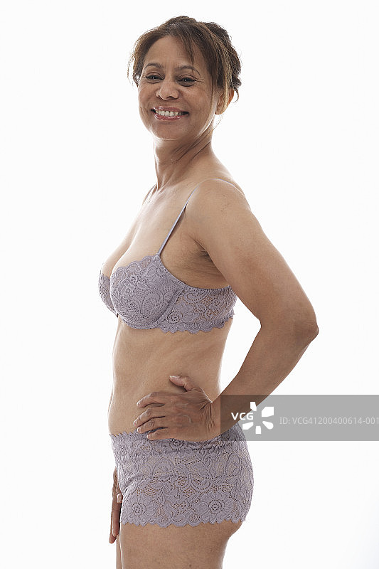 中年妇女穿着文胸和内裤，手扶着臀部图片素材