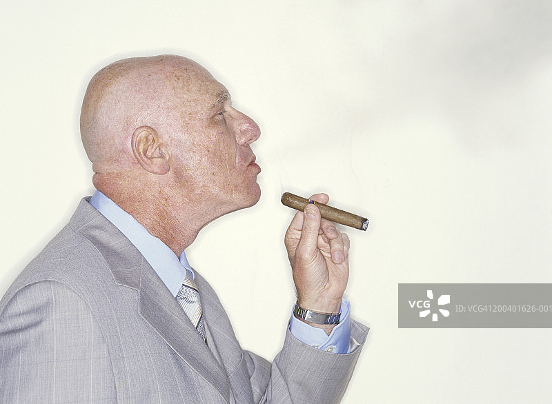 吸雪茄的年长秃头商人侧面像图片素材