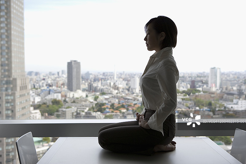 年轻女商人办公室桌前冥想侧视图图片素材