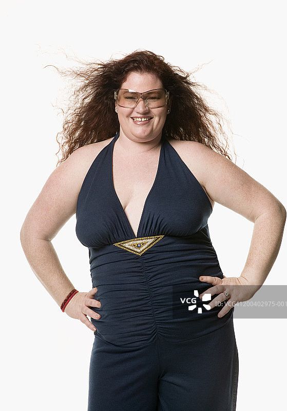 双手叉腰微笑的年轻女人肖像图片素材