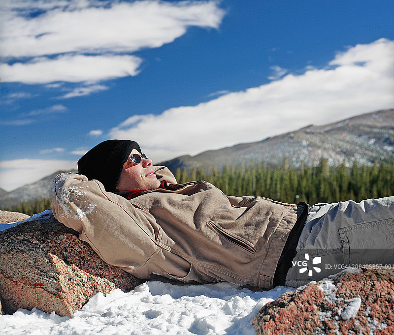 男人躺在山顶的雪地里，侧视图图片素材
