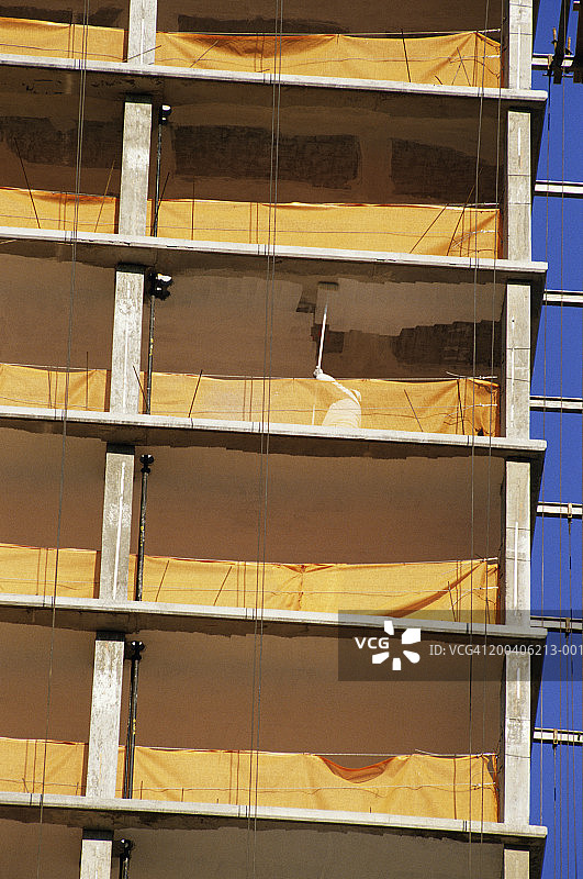 建筑工人在工地为公寓楼涂密封胶图片素材