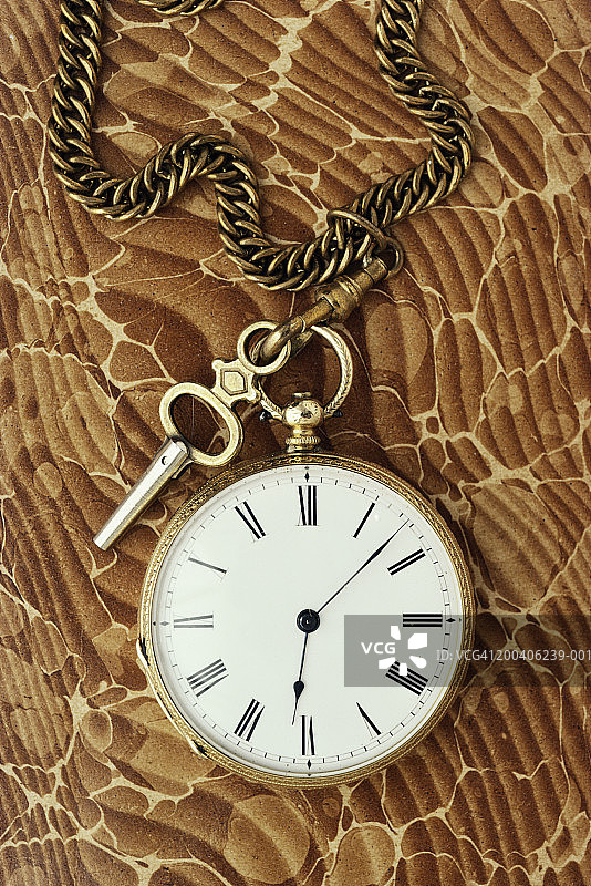 桌上的怀表、上弦钥匙和链条特写图片素材