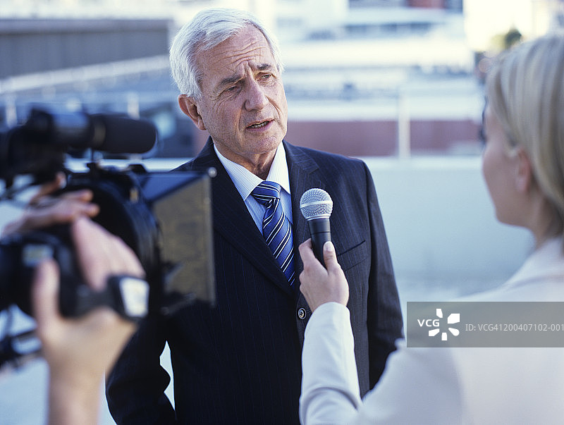 年轻女子采访年长的男人图片素材