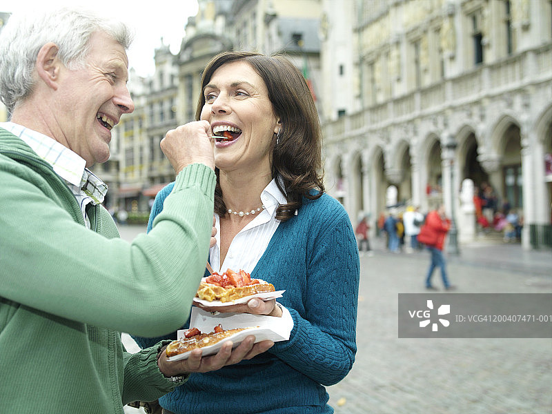 比利时布鲁塞尔：男人喂女人，面带微笑图片素材