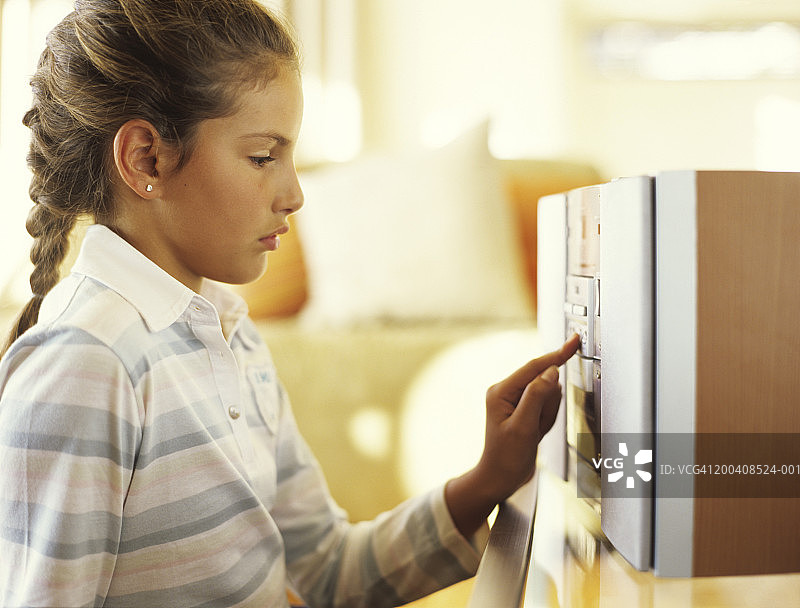 按下高保真音响按钮的女孩（9-11岁），侧视图图片素材