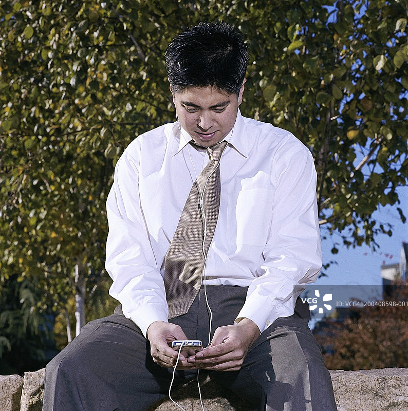 年轻商人户外听MP3图片素材