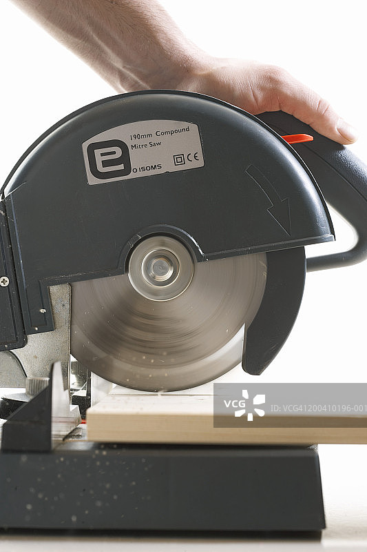 男人用圆锯切割木头，侧视图，特写图片素材