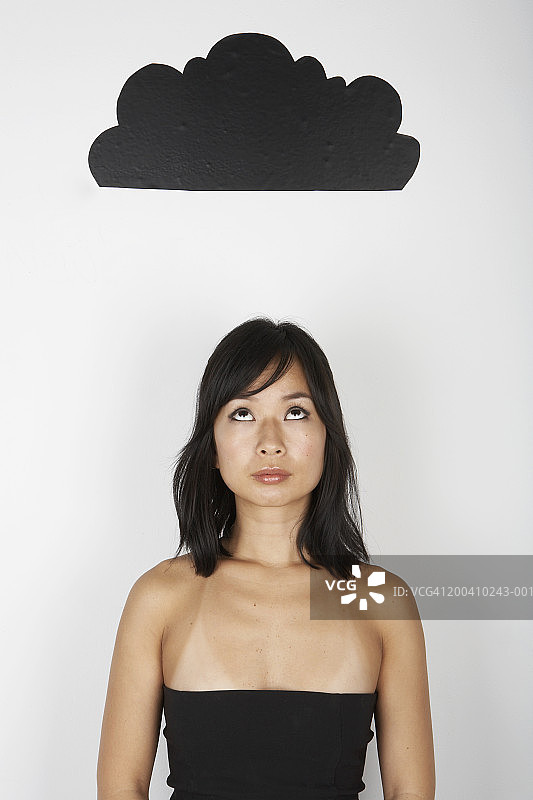 头顶乌云，抬头仰望的女人图片素材