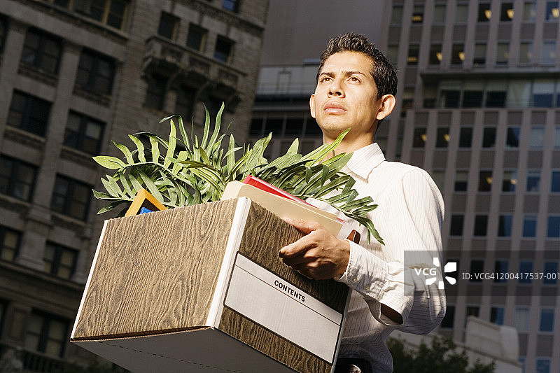 商人手持盒子望向别处图片素材