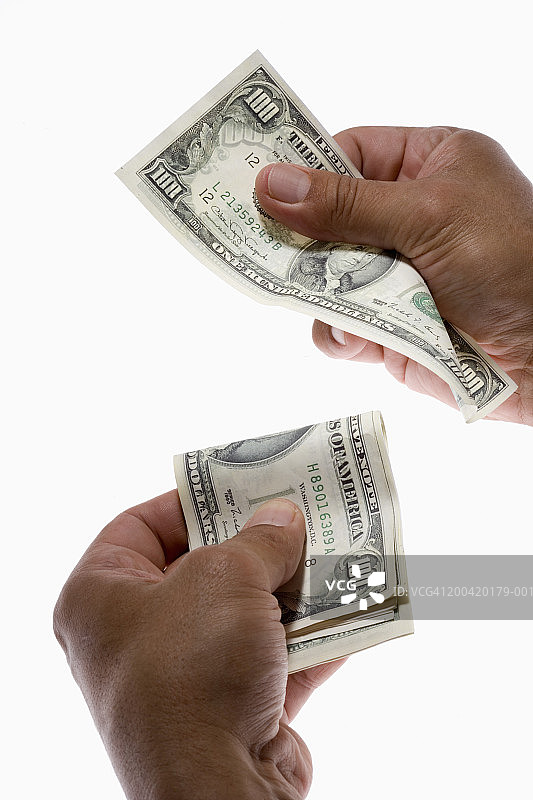 男人从一叠钱中抽出一张美元钞票特写图片素材