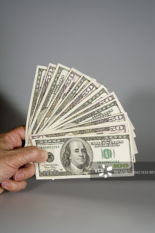 男人手持扇形美国纸币特写图片素材