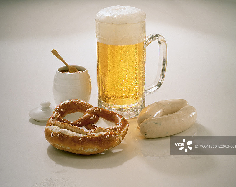 一杯啤酒配椒盐卷饼、白香肠和芥末酱图片素材