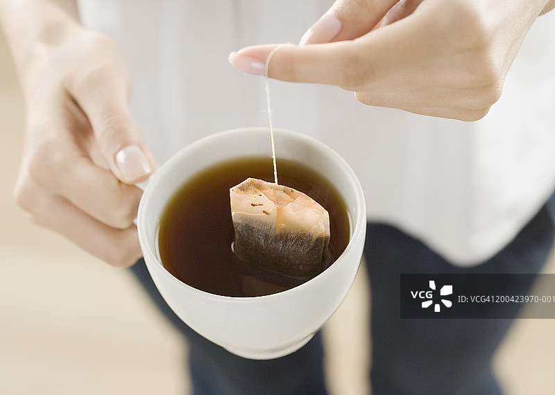 女人在杯子里泡茶包，特写，高角度图片素材