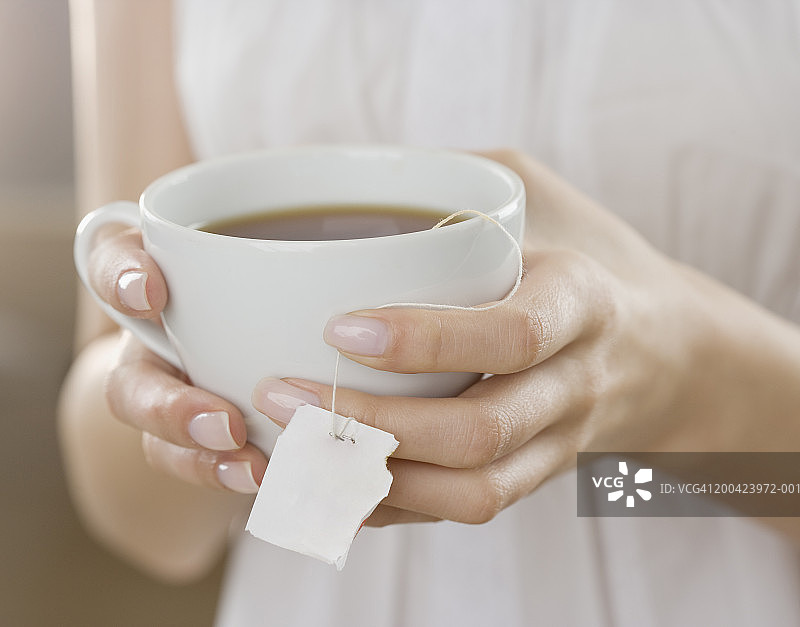 女人拿着一杯茶的特写图片素材