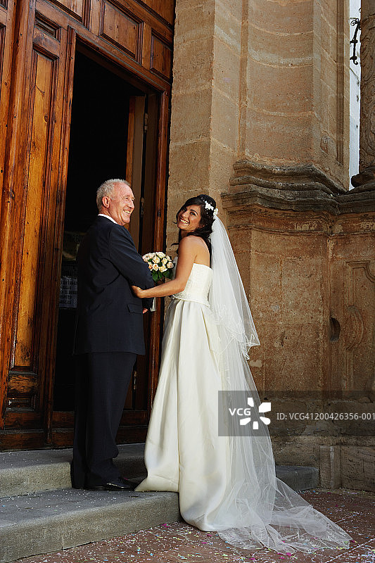 新娘和父亲微笑进入教堂图片素材