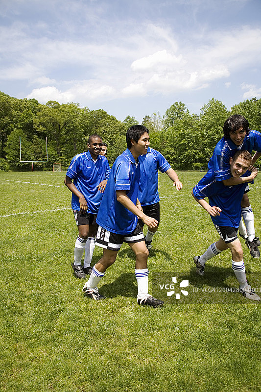 在球场上庆祝的青少年男子足球队（16-20岁）图片素材