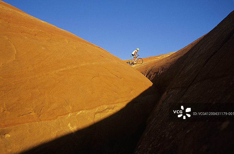 男子在岩石上骑山地自行车图片素材