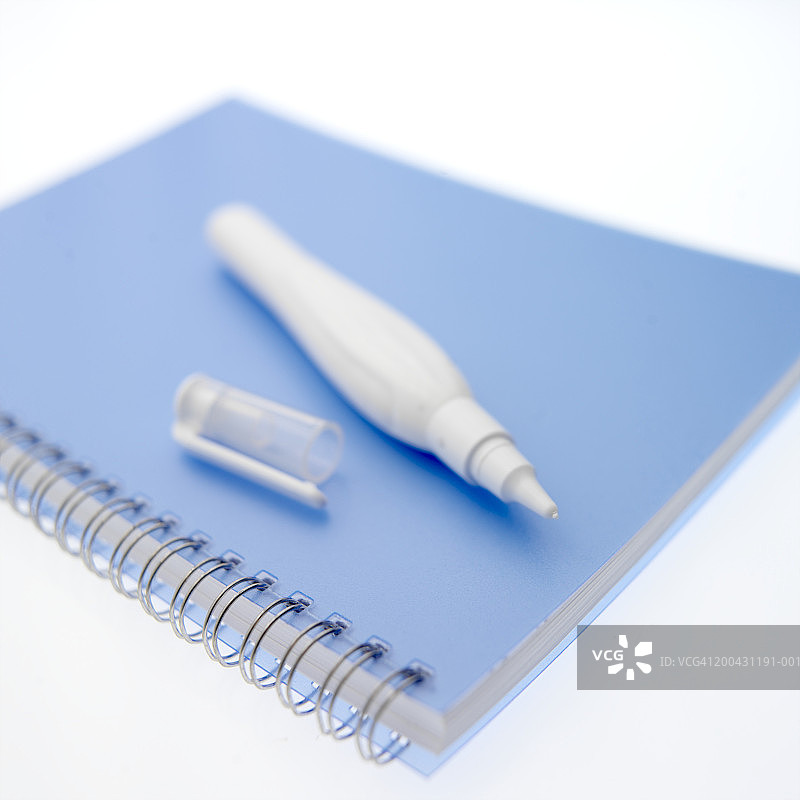 笔记本上的修正液笔，特写图片素材