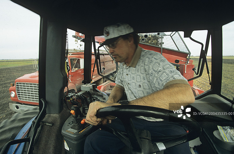 驾驶拖拉机收割的男性农民（模糊运动）图片素材