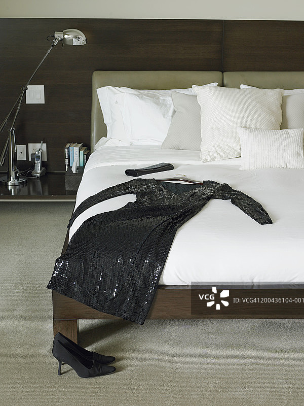床上的黑色连衣裙和钱包图片素材
