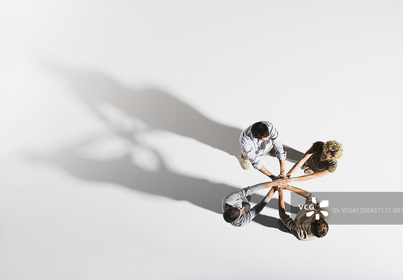 四个人手叠在一起，俯视图片素材