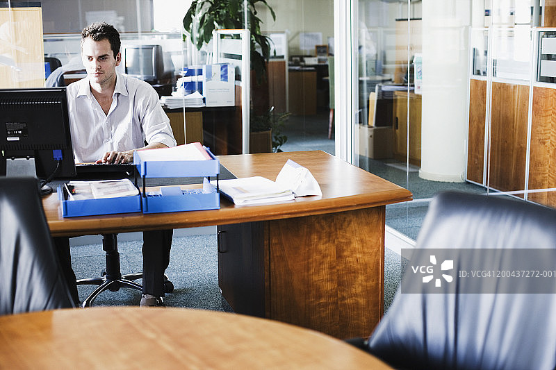 商人在办公室的办公桌前使用电脑图片素材