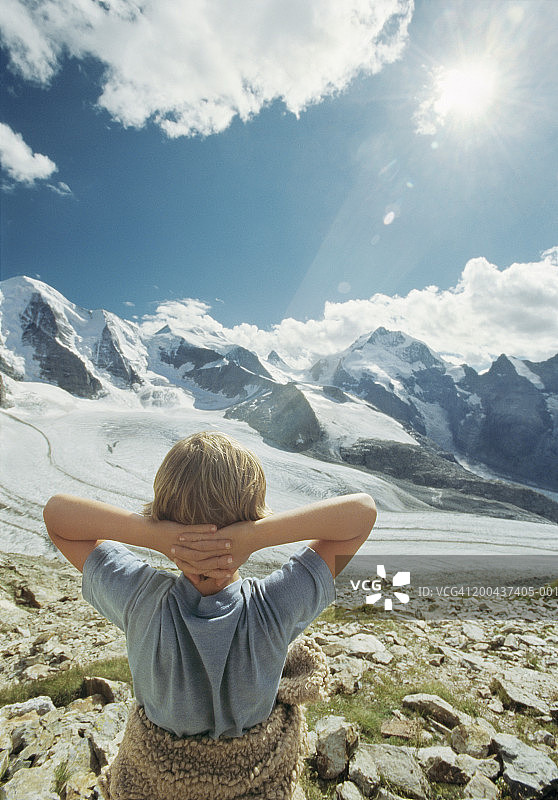 男孩（7-9岁）双手放在脑后站立，看着风景，后视图图片素材