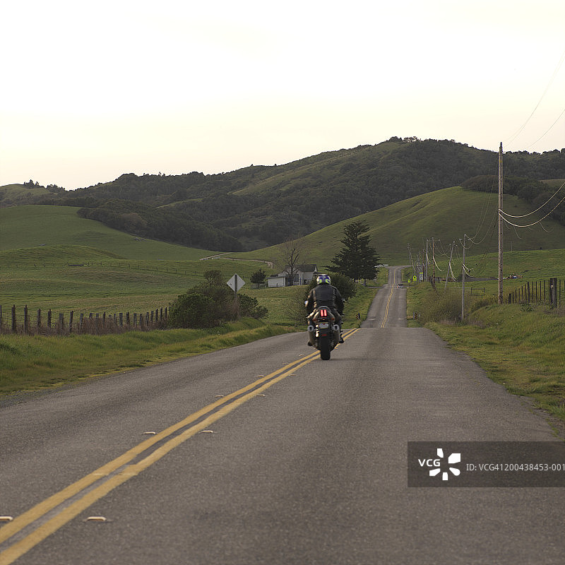 美国加利福尼亚州塞瓦斯托波尔乡村道路上的摩托车手，后视图图片素材