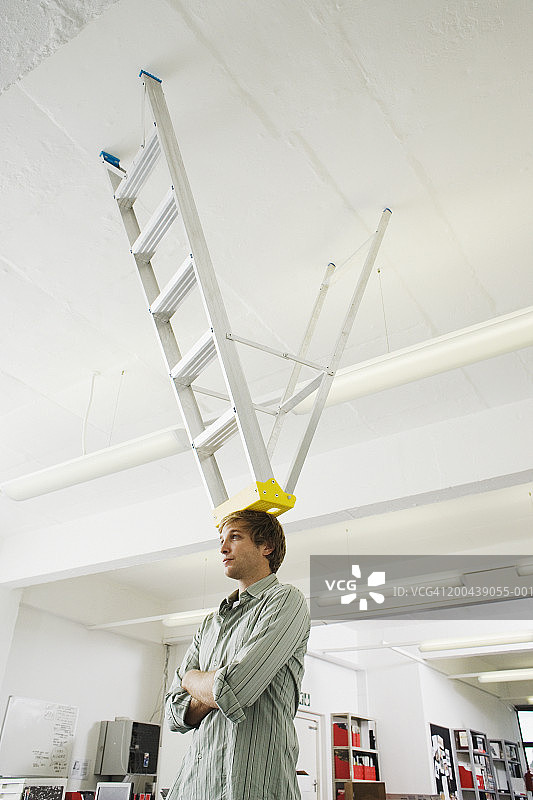 头上顶着梯子的办公室商人图片素材