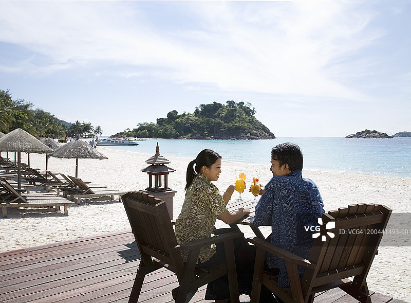 马来西亚热浪岛海滩男女饮用鸡尾酒图片素材