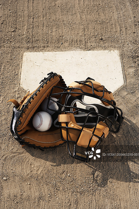 本垒板上的棒球、捕手面罩和手套（高角度）图片素材