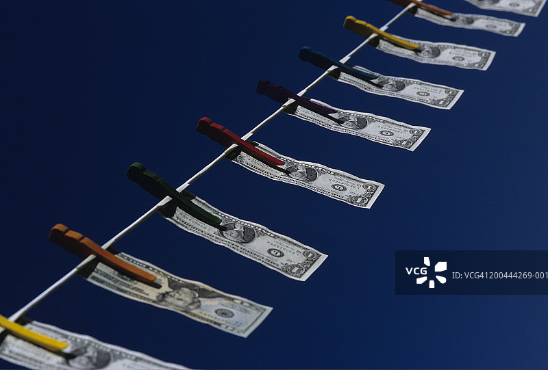 晾衣绳上悬挂的钱，低角度视图图片素材