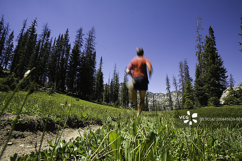 在阿尔卑斯高山地形的道路上跑步的35-40岁男人图片素材