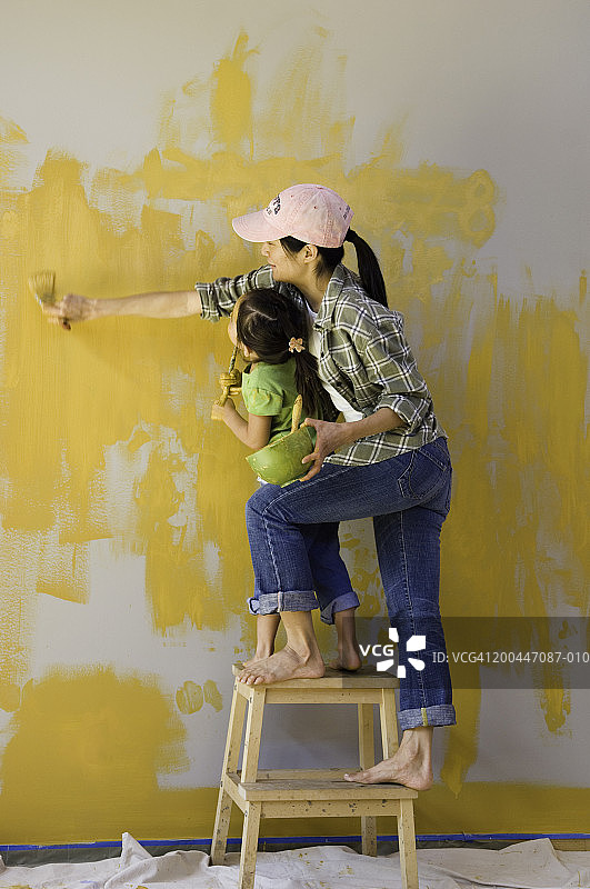 母女（4-6岁）粉刷墙壁，侧视图图片素材