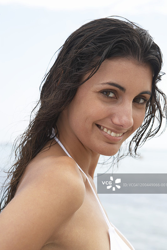 海滩上微笑的年轻女子特写肖像图片素材