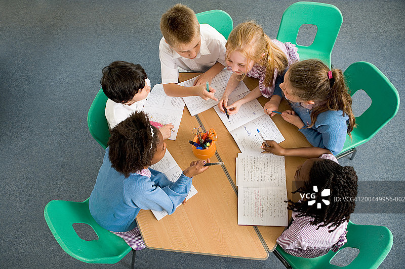 围坐在桌旁讨论的儿童（7-12岁），高角度拍摄图片素材