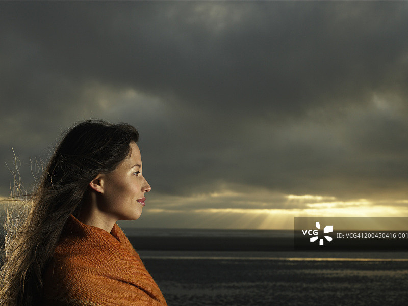 美国华盛顿州，日落时在海滩上的年轻女子侧影图片素材