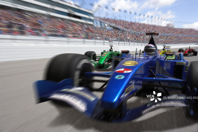 男人驾驶开轮式单座赛车（数码合成，动态模糊）图片素材