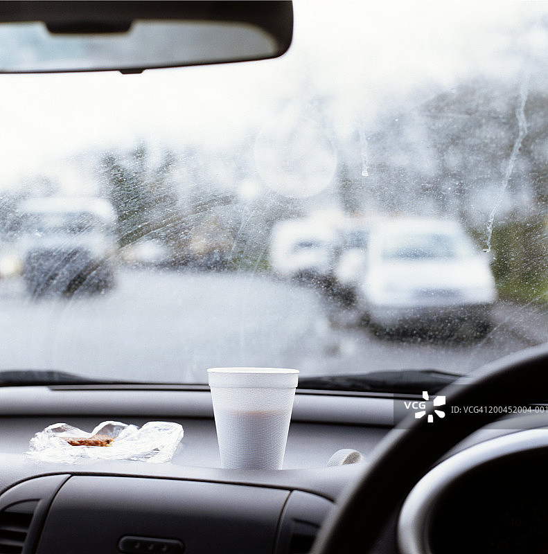 汽车仪表盘上的聚苯乙烯杯子和零食，内饰视图图片素材