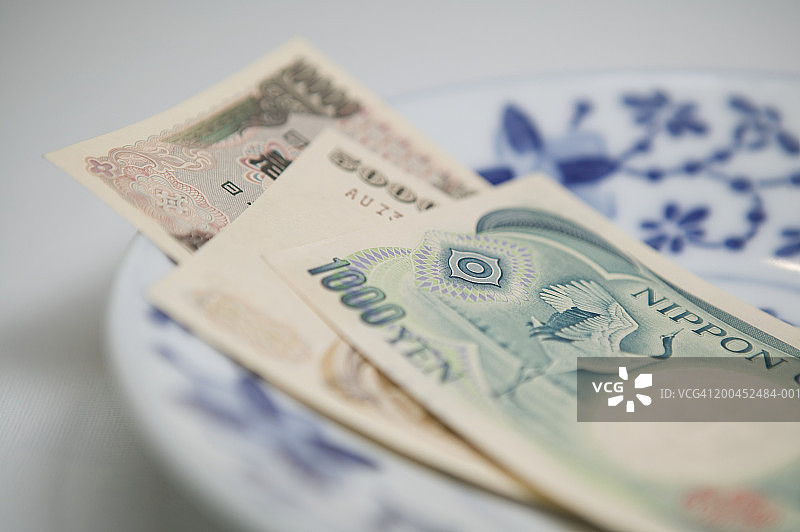 蓝色盘子上的日本纸币特写图片素材
