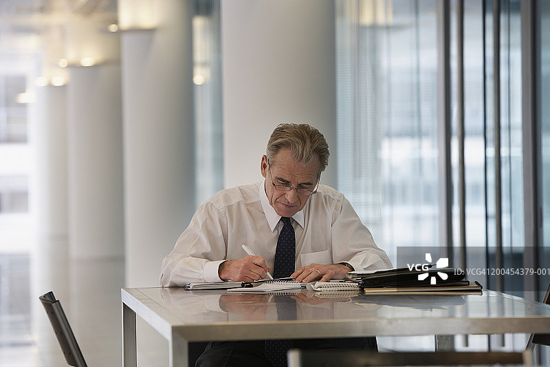 商人在办公桌上记录笔记图片素材