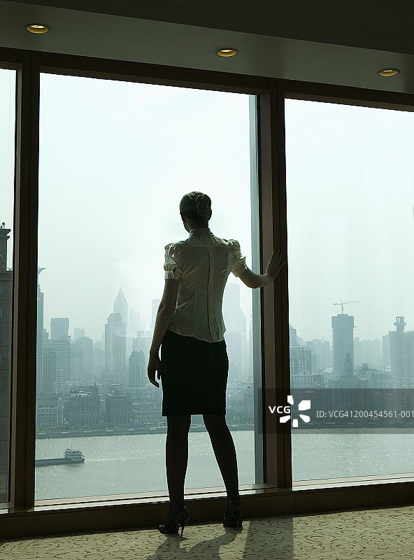 在窗户旁的女人，后视图，日出图片素材